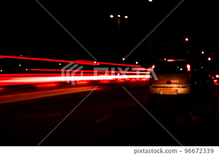 Lights of cars at night. Street line lights. Night highway city. Long exposure photograph night road. Colored bands of red light trails on the road. Background wallpaper defocused Lights of cars at night. Street line lights. Night highway city. Long exposure photograph night road. Colored bands of red light trails on the road. Background wallpaper defocused 96672339