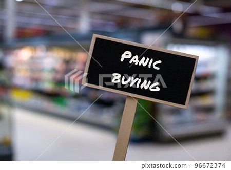 Wooden information label sign with text PANIC BUYING against defocused store shelves message. Global hunger, inflation, high prices, increasing living expenses and poverty, financial crisis, food 96672374