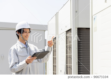 Male worker inspecting the outdoor unit Male worker inspecting the outdoor unit 96673104