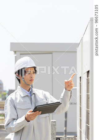 Male worker inspecting the outdoor unit Male worker inspecting the outdoor unit 96673105