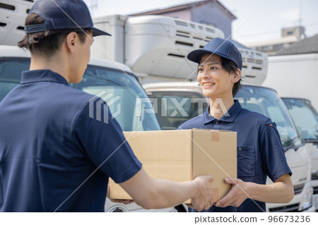 A colleague handing a package to a delivery person in the area in charge A colleague handing a package to a delivery person in the area in charge 96673236
