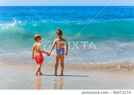 Happy kids have fun in sea surf on sea beach. 96673274