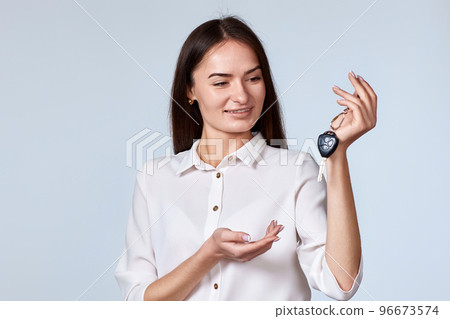 smiling brunette woman holding car keys 96673574