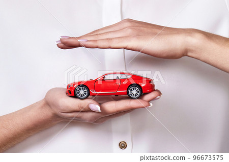 beautiful woman in white shirt holding little red car 96673575