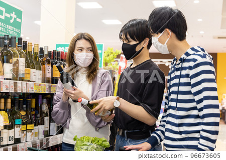 Students choosing alcohol at the supermarket 96673605