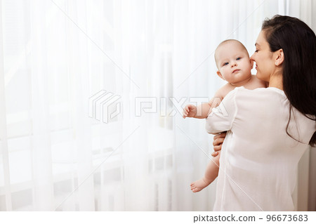 Happy mother holding and hugging adorable newborn baby Happy mother holding and hugging adorable newborn baby 96673683