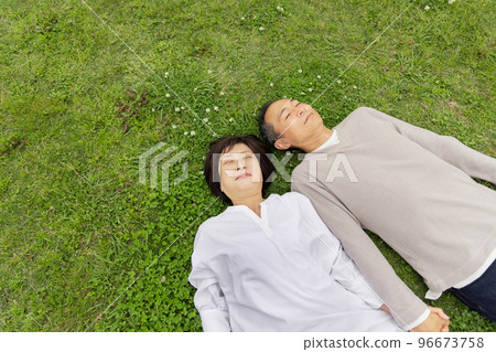 Senior couple lying on the lawn Senior couple lying on the lawn 96673758