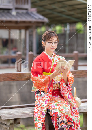 A woman in a kimono reading a book A woman in a kimono reading a book 96673962
