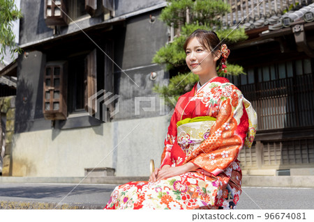 A kimono woman sitting on a stone staircase and taking a break 96674081
