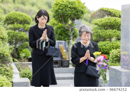 Parents and children visiting the grave 96674252