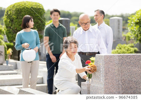 Senior woman cleaning the grave 96674385