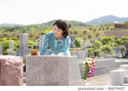 A woman cleaning a tombstone A woman cleaning a tombstone 96674407