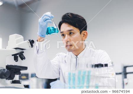 Young man checking test tubes Young man checking test tubes 96674594