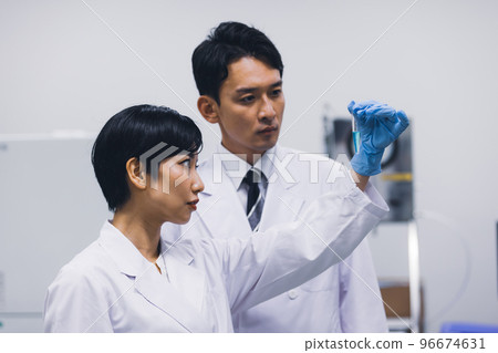 一名身穿白大褂的研究員確認測試結果 96674631
