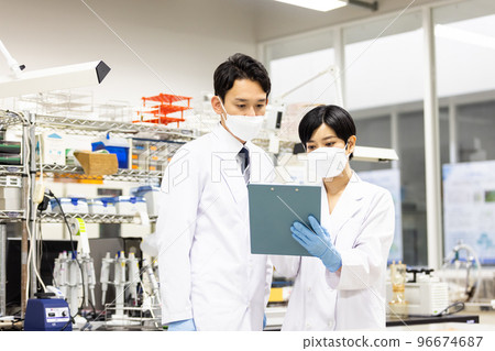 Men wearing white coats to check test results 96674687