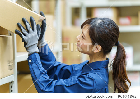 Female worker working in a warehouse 96674862
