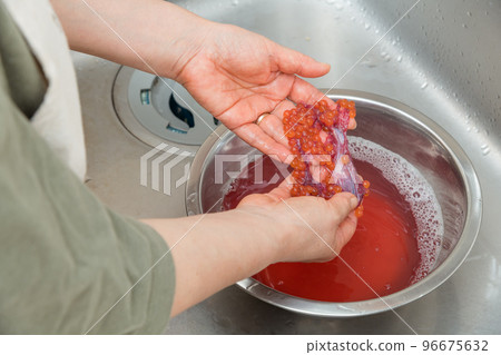 [To make salmon roe marinated in soy sauce, put raw salmon roe in lukewarm water with salt] 96675632