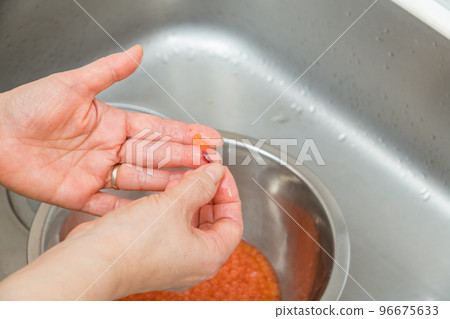 [To make salmon roe marinated in soy sauce, put raw salmon roe in lukewarm water with salt] 96675633