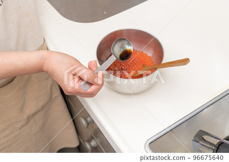 [將洗淨的三文魚子浸泡在醬汁中] 96675640