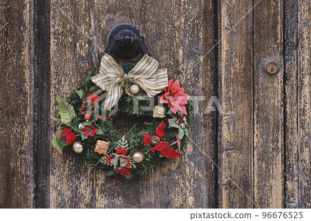 Christmas crown wreath upon an old wooden door. Traditional home decor during Christmas, copy space Christmas crown wreath upon an old wooden door. Traditional home decor during Christmas, copy space 96676525