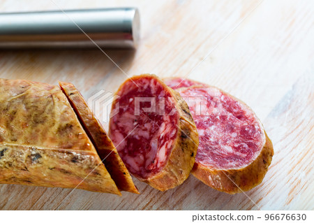 Close-up of spanish salchichon sausage at wooden surface Close-up of spanish salchichon sausage at wooden surface 96676630
