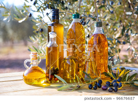 Olive oil on wooden table on background of olive tree 96676687