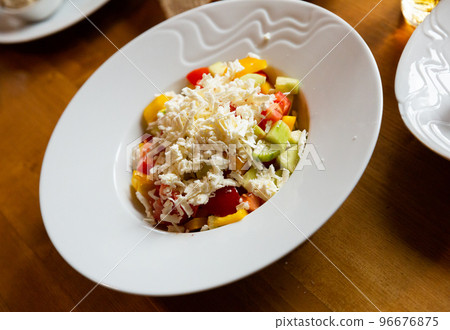 Dish of Balkan cuisine Shopska salad with cucumbers, tomatoes, bell peppers and brynza  96676875