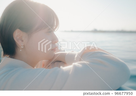 Photo of a young woman standing on the beach 96677950