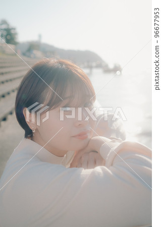 Photo of a young woman standing on the beach 96677953