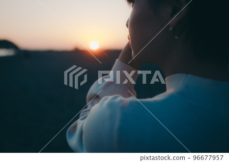 Photo of a young woman standing on the beach 96677957