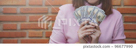 Close up of woman holding dollar bills. 96677990