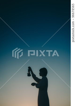 Photo of a young woman with a lantern 96678565