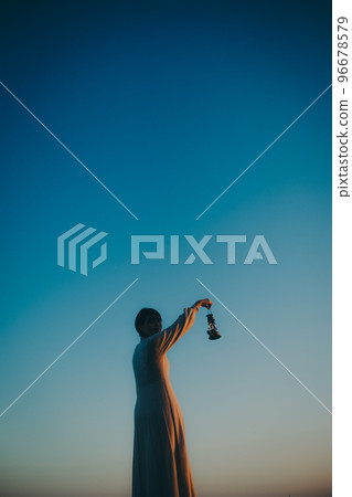 Photo of a young woman with a lantern Photo of a young woman with a lantern 96678579