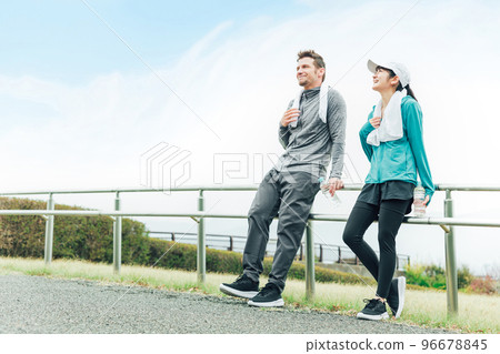 International couple man and woman wearing sportswear taking a break after exercising for diet 96678845
