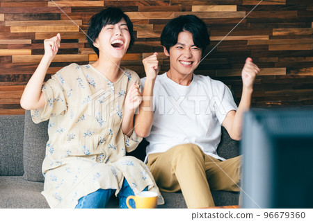 夫妻一邊看電視一邊分享快樂 96679360