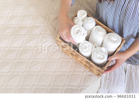 Woman hands neatly folded linens and towels. Japanese storage method. Woman hands neatly folded linens and towels. Japanese storage method. 96681031