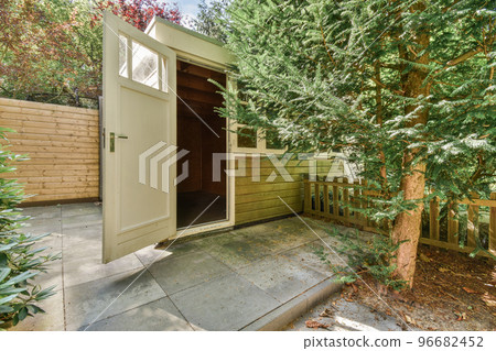 Simple small patio with small garden near wooden fence 96682452