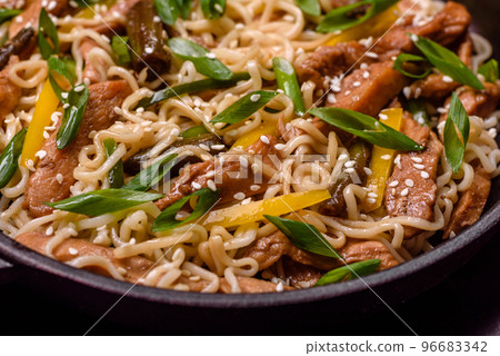 Tasty dish of Asian cuisine with rice noodles, chicken, asparagus, pepper, sesame seeds and soy sauce 96683342