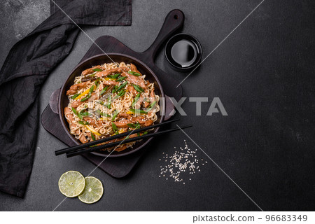 Tasty dish of Asian cuisine with rice noodles, chicken, asparagus, pepper, sesame seeds and soy sauce 96683349
