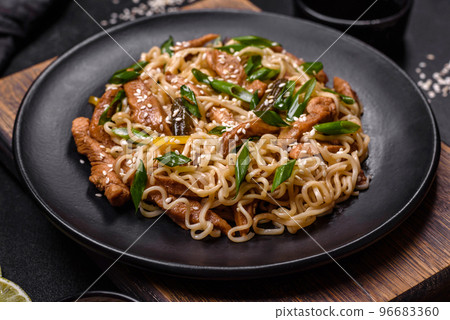 Tasty dish of Asian cuisine with rice noodles, chicken, asparagus, pepper, sesame seeds and soy sauce Tasty dish of Asian cuisine with rice noodles, chicken, asparagus, pepper, sesame seeds and soy sauce 96683360