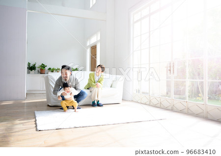 Image of a couple watching a cute child in the living room 96683410