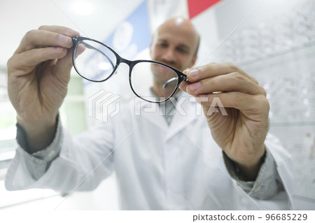 Optician suggesting new eyeglasses frame to clients. Optician suggesting new eyeglasses frame to clients. 96685229