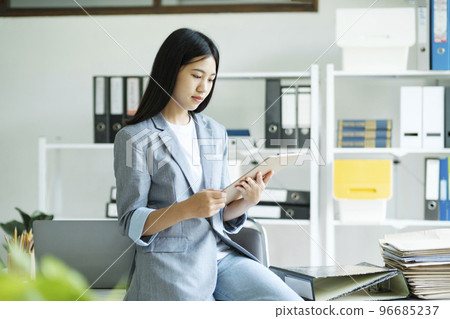 Young asian businesswoman working at office using laptop. 96685237