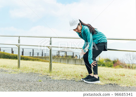 Asian woman having calf pain while exercising in the park Asian woman having calf pain while exercising in the park 96685341