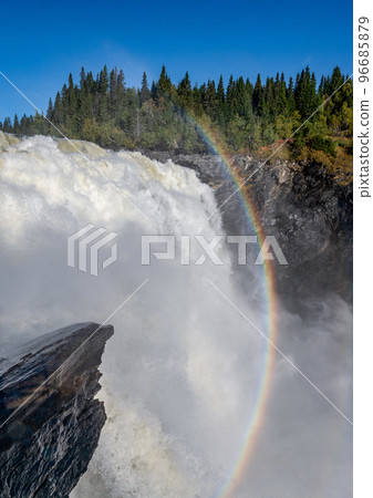 Famous waterfall Tannforsen northern Sweden, with a rainbow in the mist and rapid flowing cascades of water Famous waterfall Tannforsen northern Sweden, with a rainbow in the mist and rapid flowing cascades of water 96685879