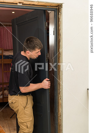 The craftsman installs the door leaf on the hinged hinge. The craftsman installs the door leaf on the hinged hinge. 96688946