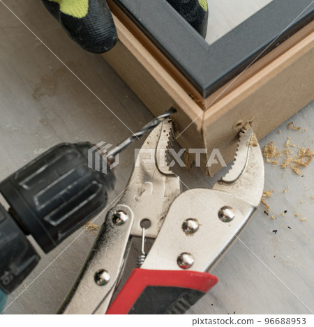 The craftsman drills the door for connection at the corner, the clamps hold the two slats of the door. 96688953