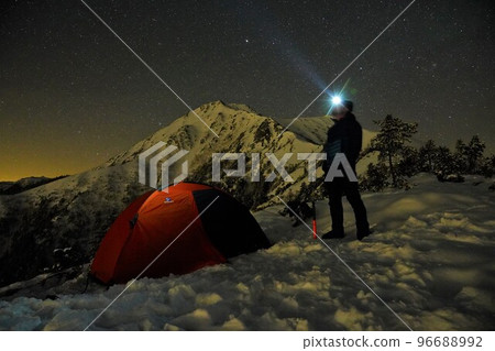 Tents set up on the east ridge, winter at night, Mt. Jonen, the starry sky, and climbers 96688992