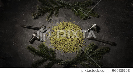 hope for a granular on a dark background with male instruments. An ingredient for industrial beer production. Decorations from the Christmas tree 96688998