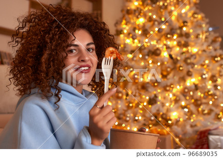 woman eating sushi, asian food restaurant, romantic evening, eating sushi with chopsticks, sushi delivery and takeout, eating at home, romantic dinner alone in christmas decor. Eve New year, saving woman eating sushi, asian food restaurant, romantic evening, eating sushi with chopsticks, sushi delivery and takeout, eating at home, romantic dinner alone in christmas decor. Eve New year, saving 96689035